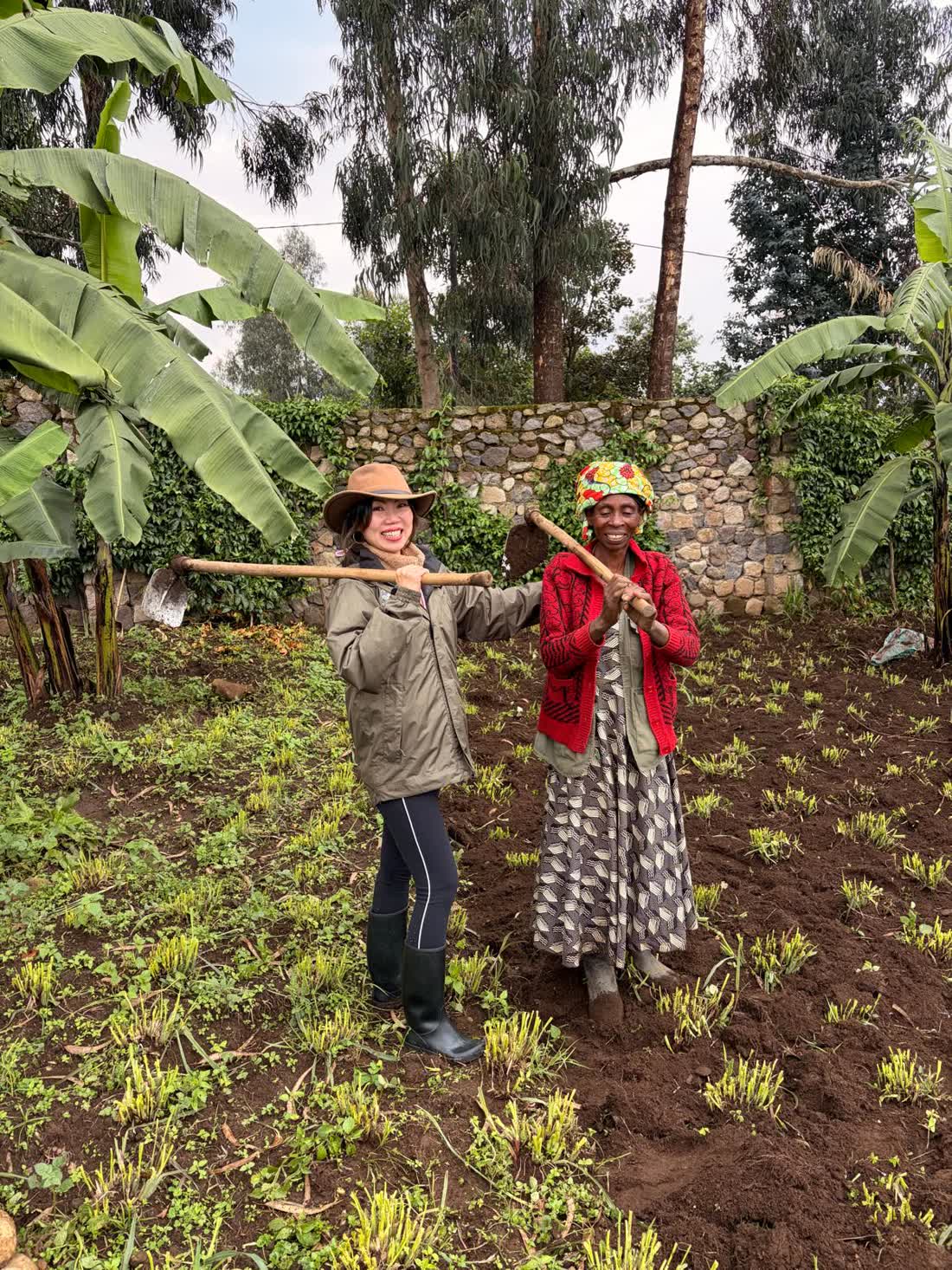 Annie Brent walking along a rural path with Rwandan farmers