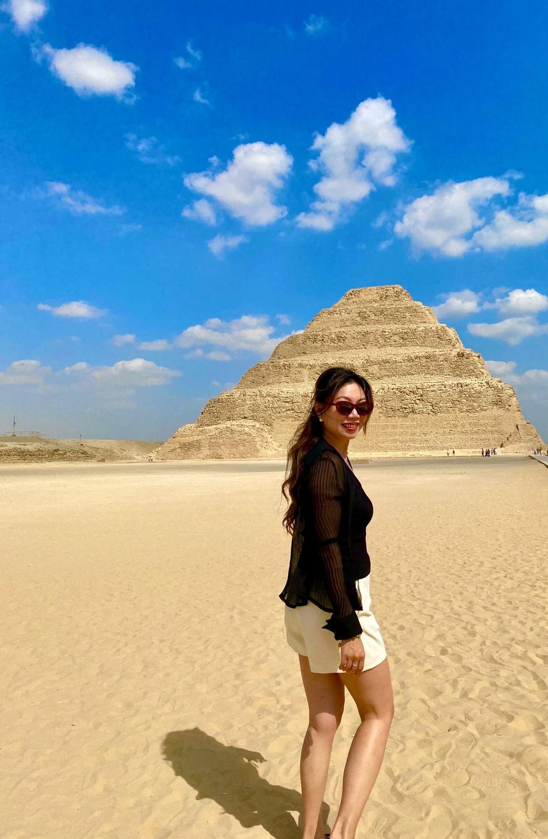 Annie Brent standing in the sand before the Step Pyramid of Djoser at Saqqara