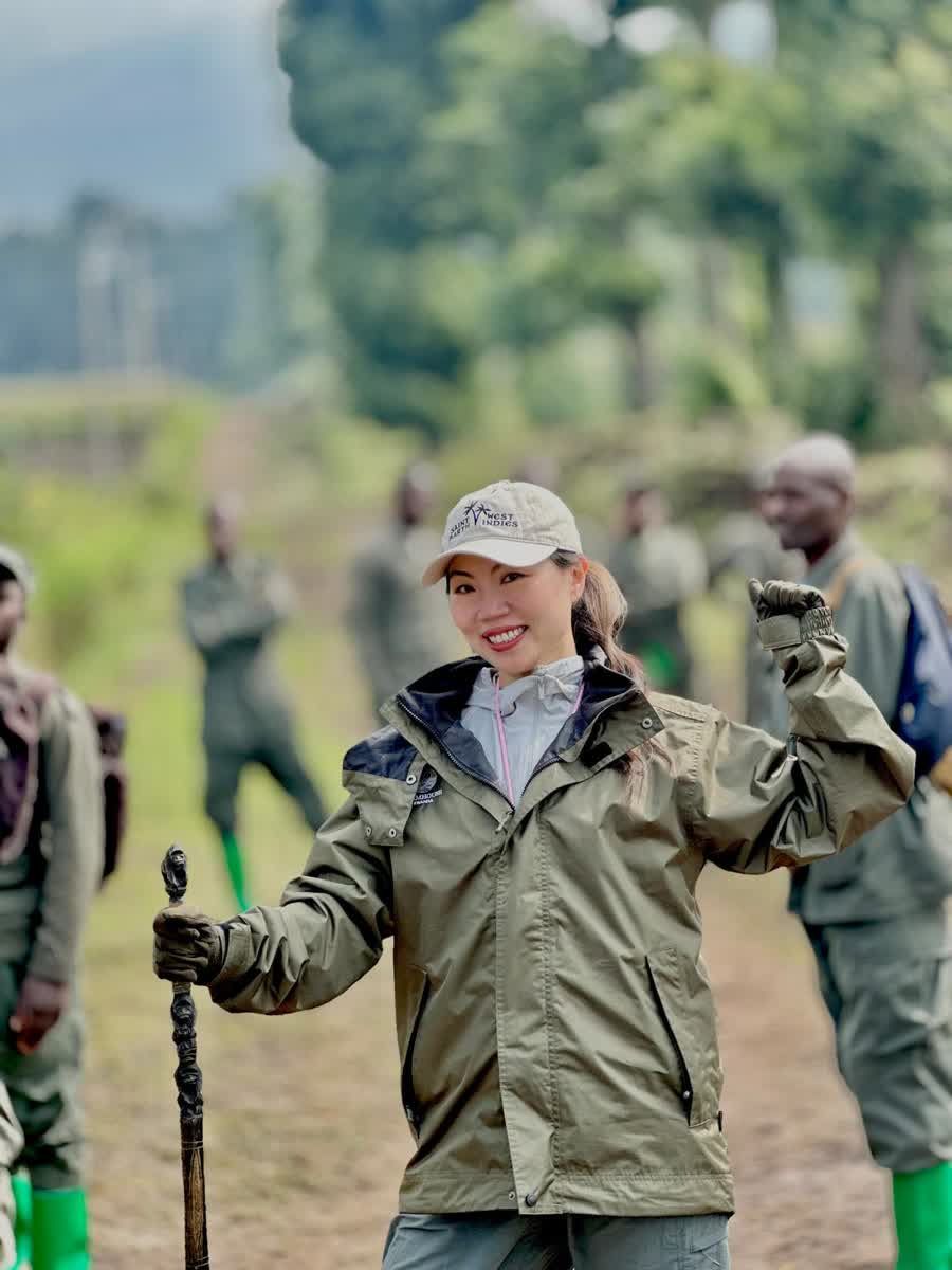 Annie Brent standing on a forest trail with Rwandan trek rangers