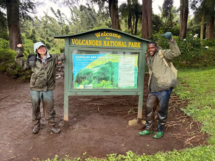 Visitors and guides gathered beside the Volcanoes National Park sign